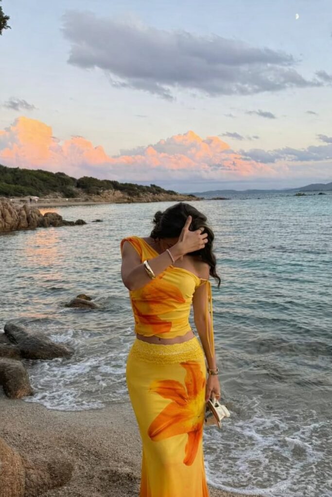 Woman wearing a yellow floral one shoulder two piece set, perfect for summer vacation and beach outings.