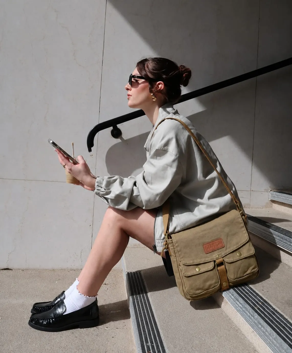 Woman carrying a stylish canvas messenger bag that looks designer but costs less, perfect for work, travel, and everyday use