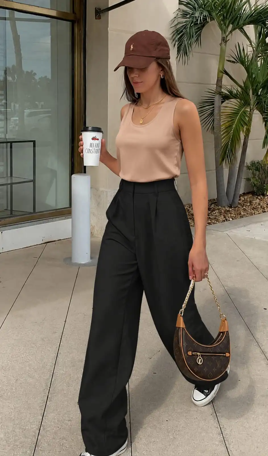 Woman wearing black wide leg dress trousers with a satin camisole top for an elegant summer outfit inspiration.