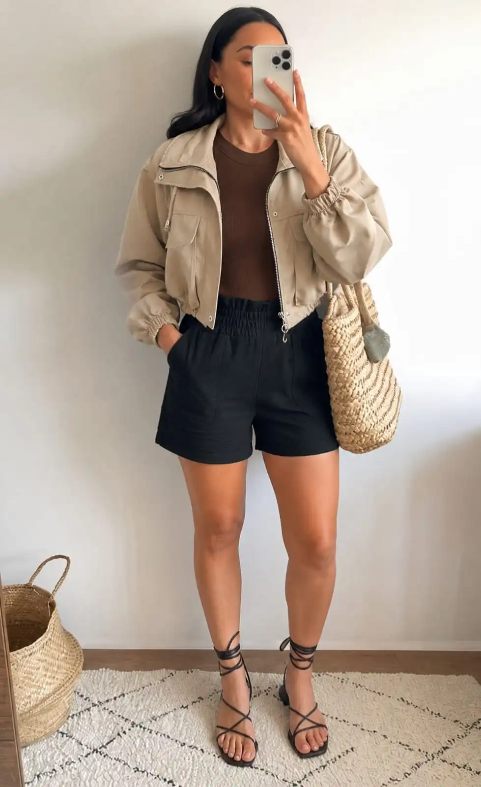 Casual summer outfit featuring a cropped utility jacket, ribbed tank top, and black shorts for cool summer evenings.