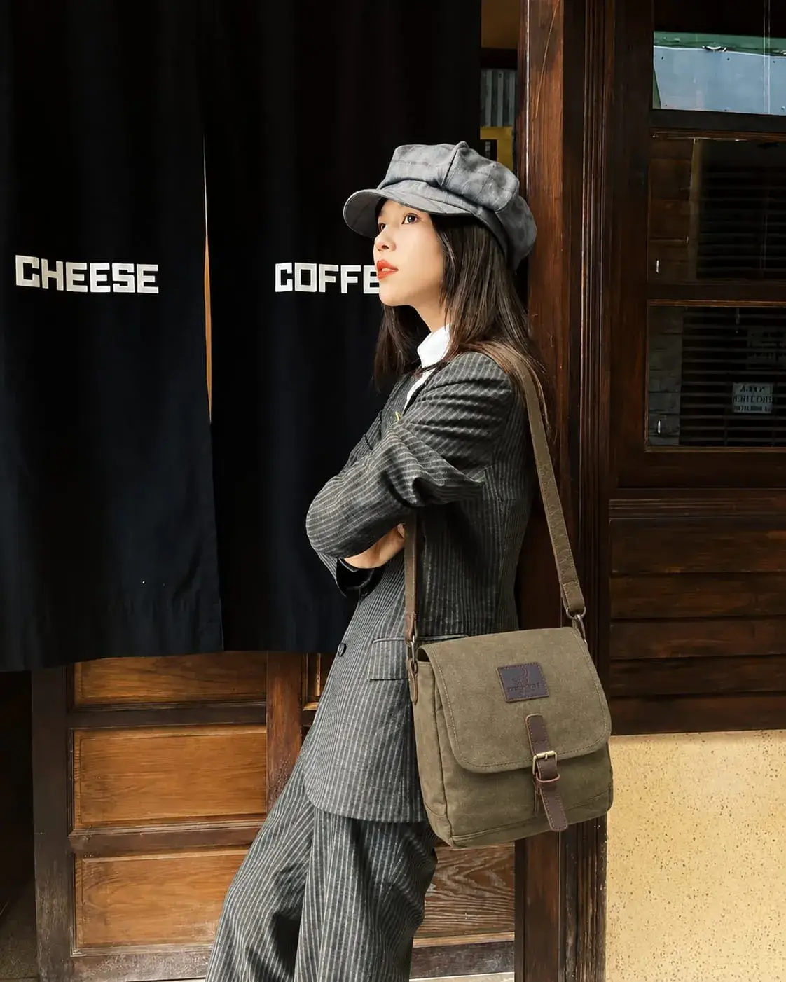 Woman wearing a stylish canvas messenger bag with a designer-inspired look, perfect for work, commuting, and everyday carry