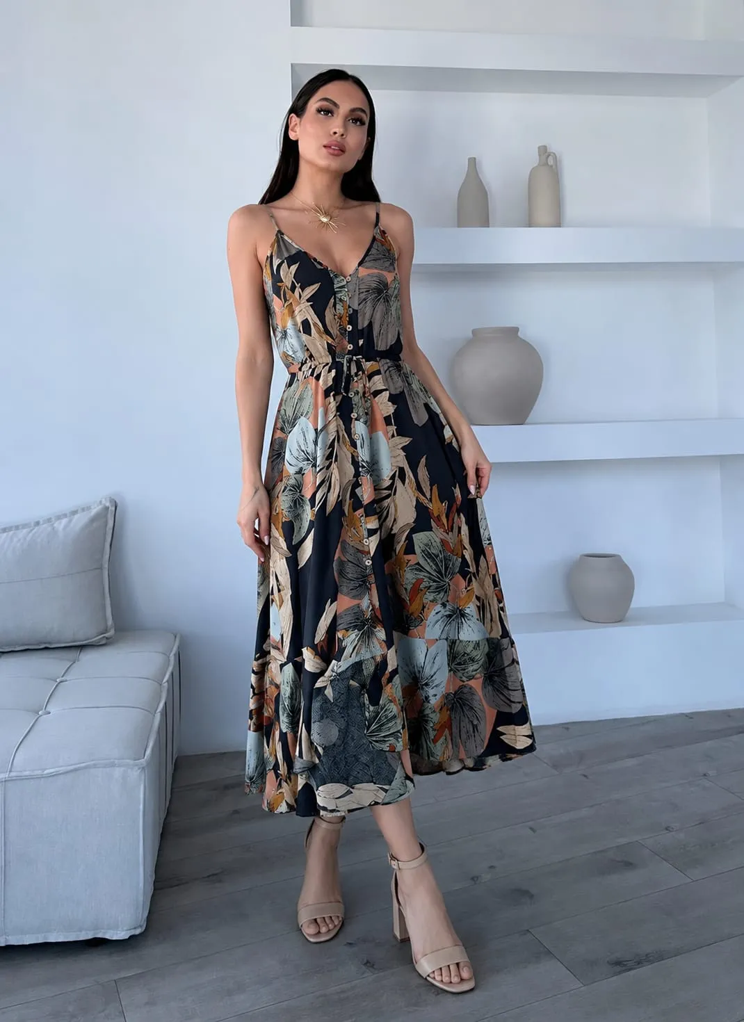 Woman wearing a floral midi dress with neutral heels, perfect graduation guest outfit for spring and summer ceremonies.