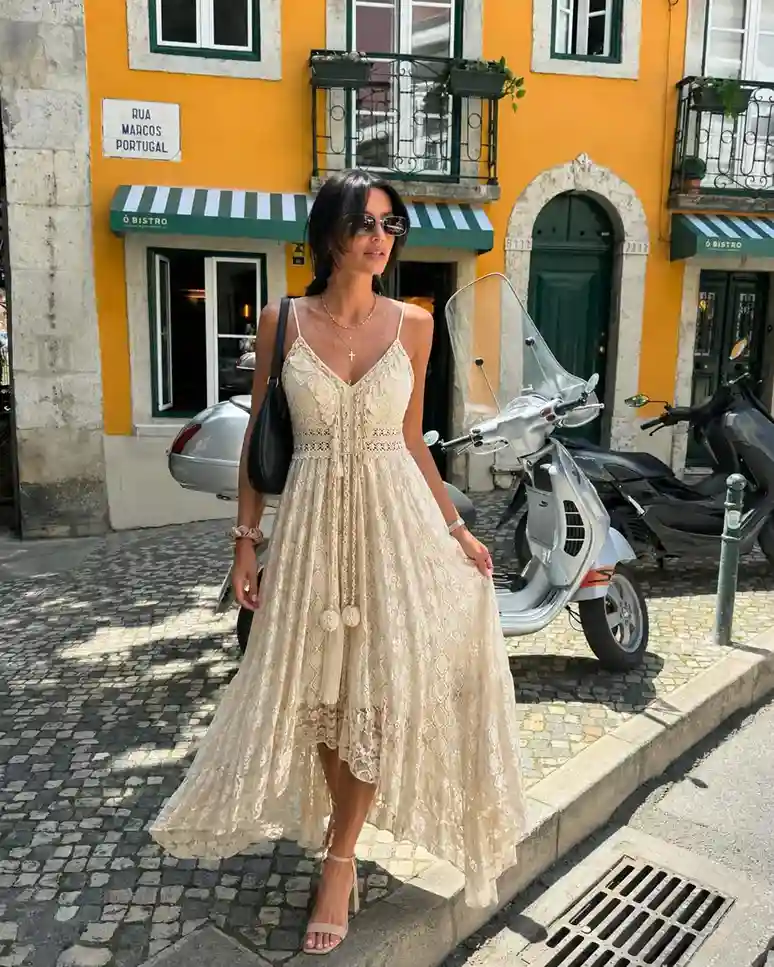 Lace white boho maxi dress outfit with layered jewelry, shoulder bag, and heels for an expensive-looking summer vacation style.