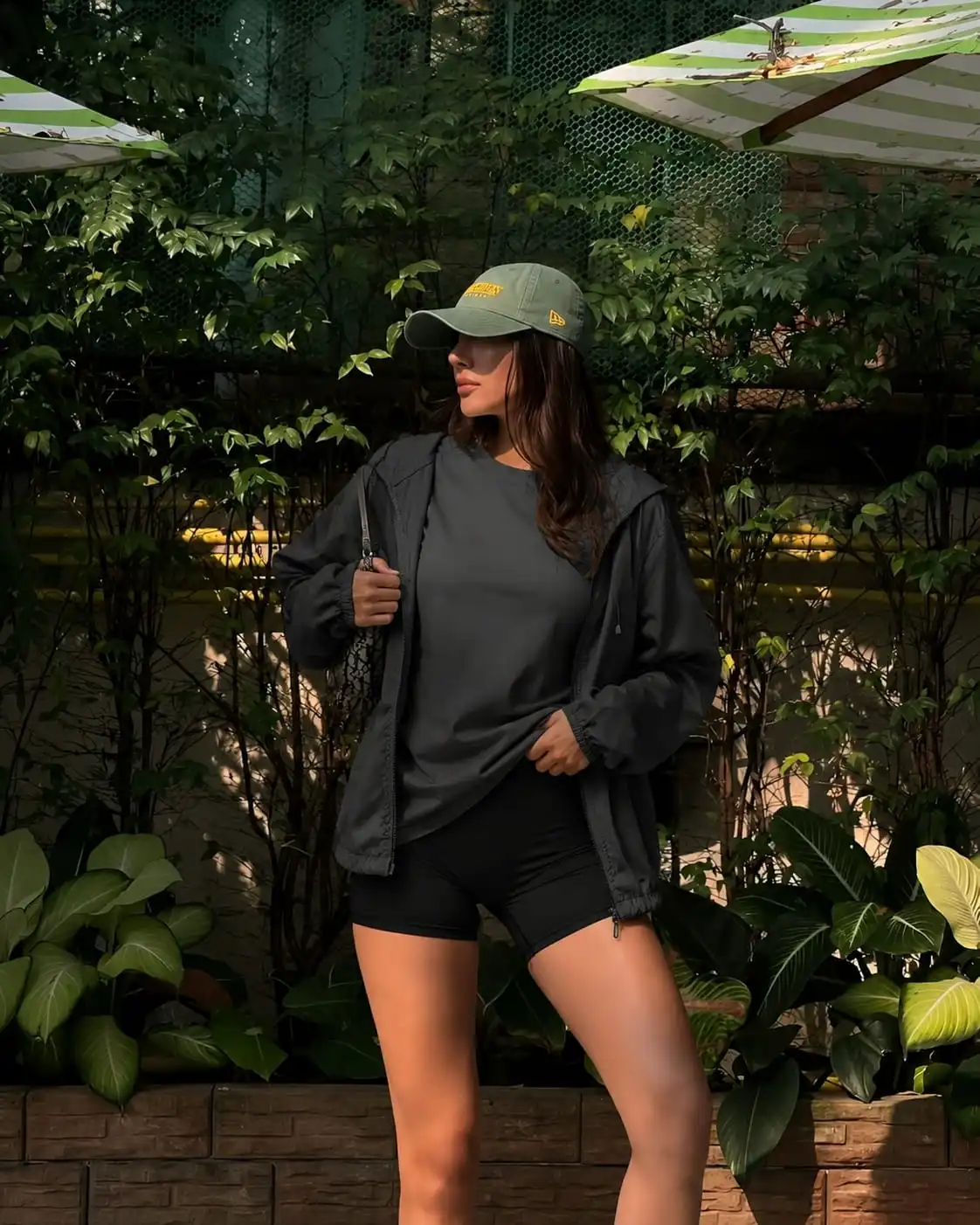 Sporty summer evening outfit with a lightweight windbreaker, oversized t-shirt, and biker shorts for comfortable layering.