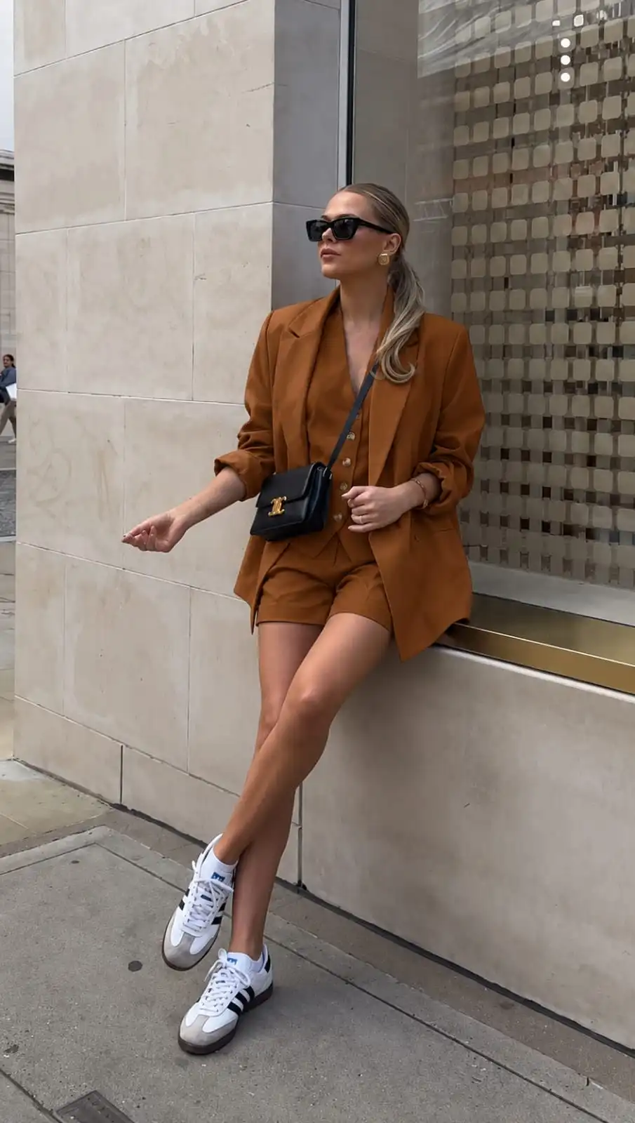 Chic summer outfit featuring an oversized blazer layered over a matching vest and tailored shorts set for cool evenings.