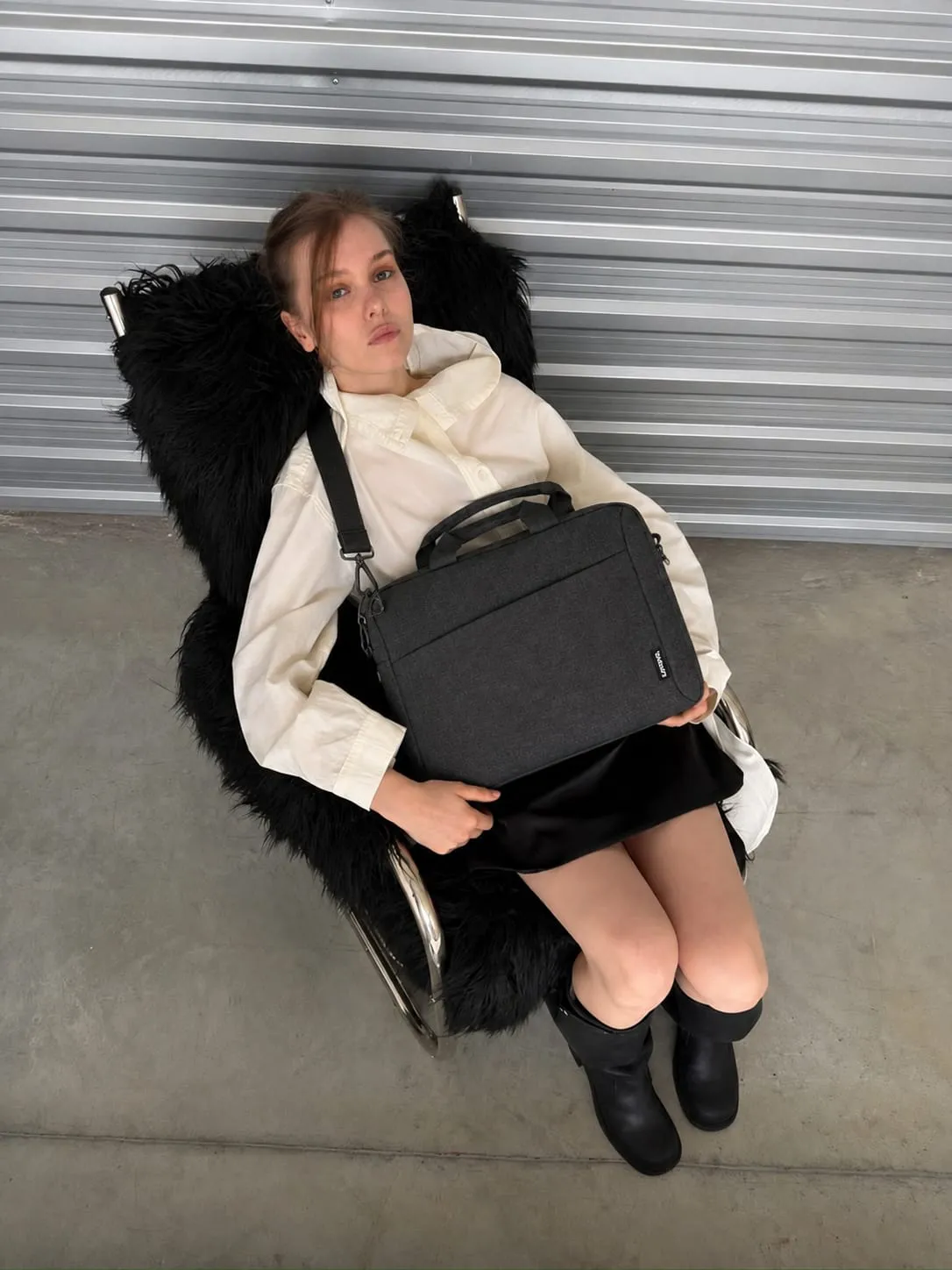 Woman holding a professional laptop messenger bag with a sleek designer-inspired look, ideal for work, business travel, and daily commuting