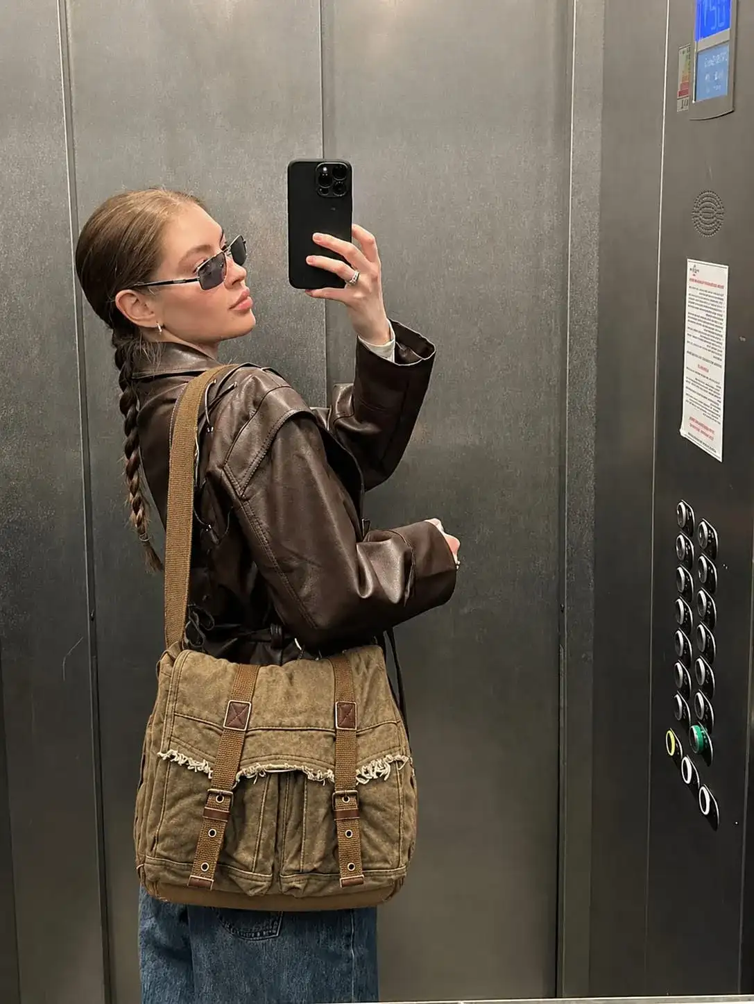 Woman carrying a vintage canvas messenger bag with a designer-inspired look, featuring a stylish crossbody design for everyday use and travel