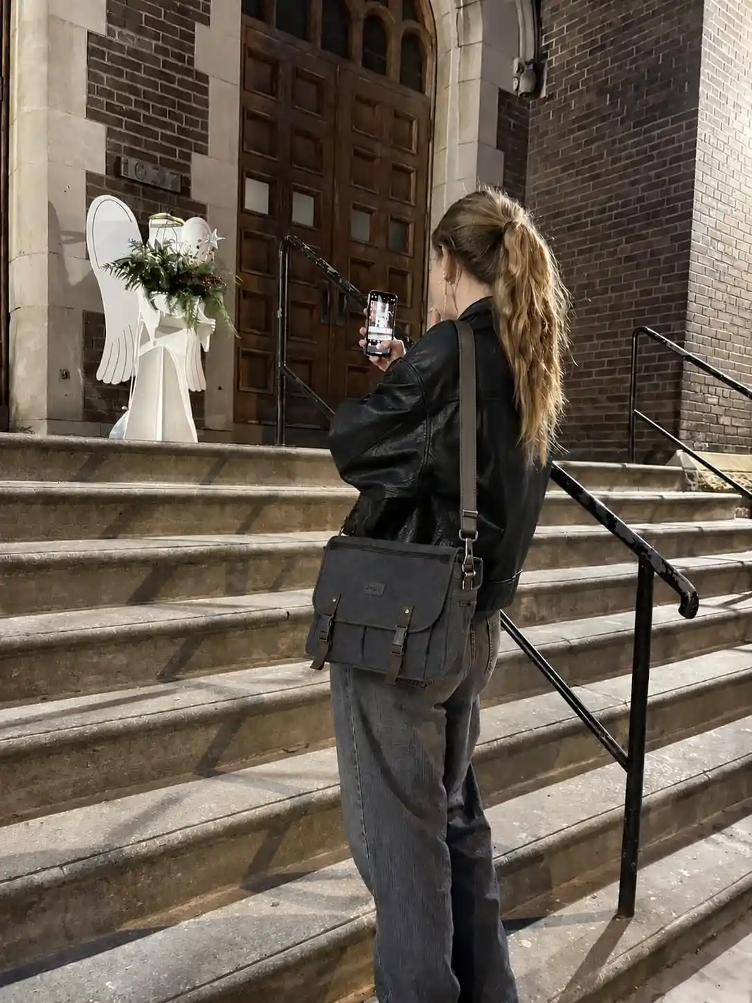 Woman wearing a vintage-style messenger bag with a designer-inspired look while walking outdoors, perfect for daily commuting and casual use