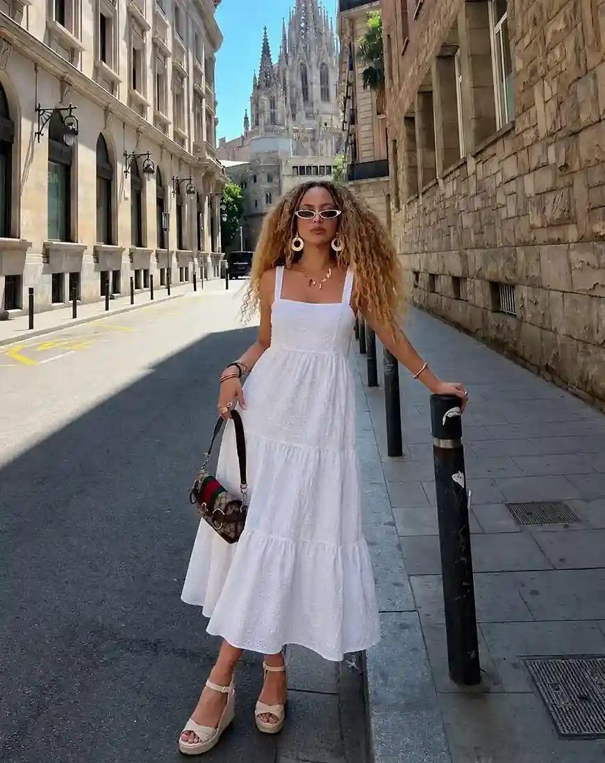 White eyelet boho midi dress outfit with espadrille wedges and statement earrings for an expensive-looking summer travel style.