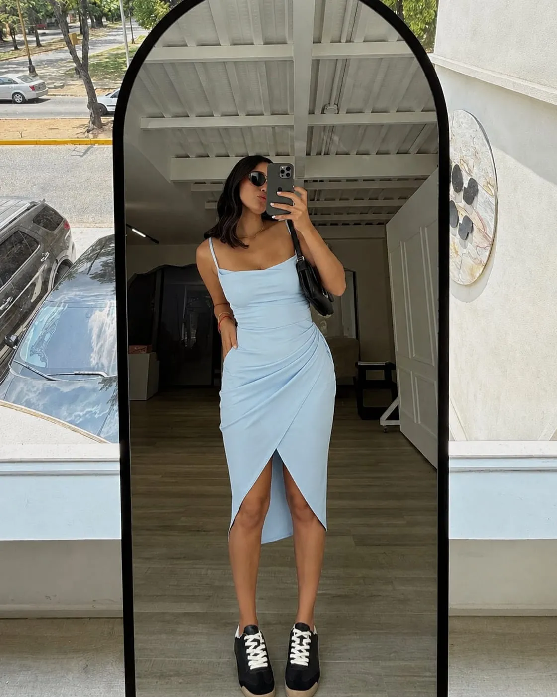 Woman wearing an elegant blue satin midi dress showing how to dress classy on a budget with affordable fashion.