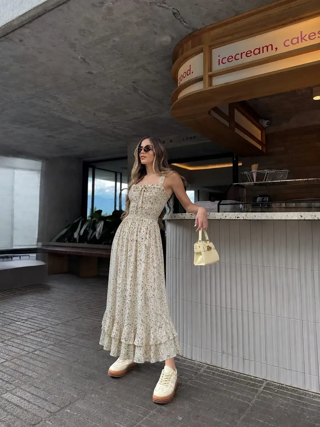 Woman wearing a light floral maxi dress with timeless feminine style for affordable elegant outfits.