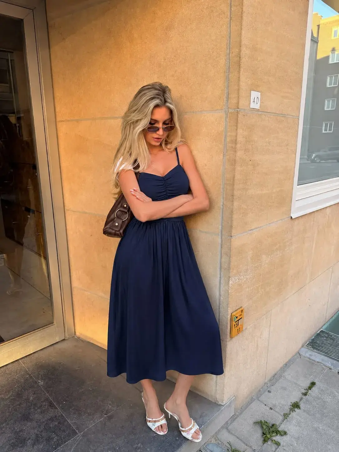 Woman wearing a navy ruched maxi dress for elegant affordable fashion and classy style inspiration.