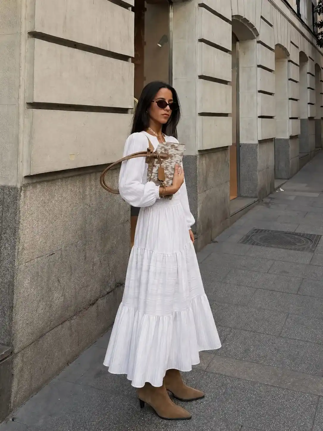 Woman wearing a white puff sleeve midi dress with elegant minimalist styling for budget-friendly fashion.